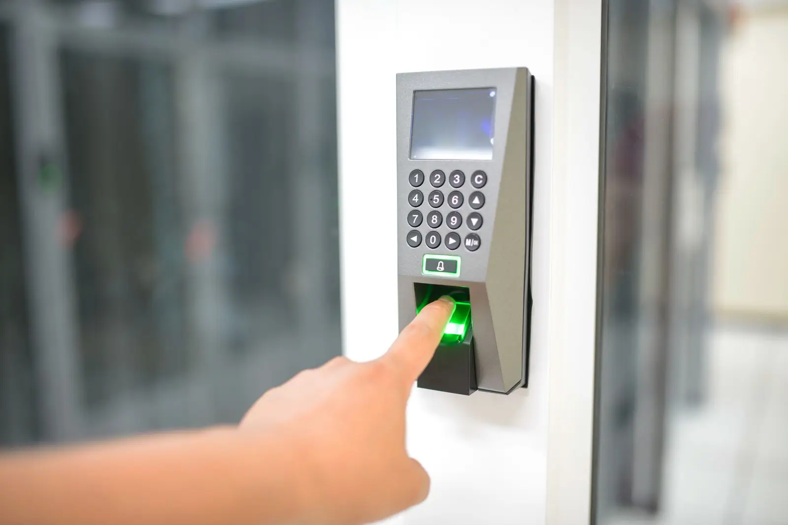 A person using a fingerprint reader on an entry panel