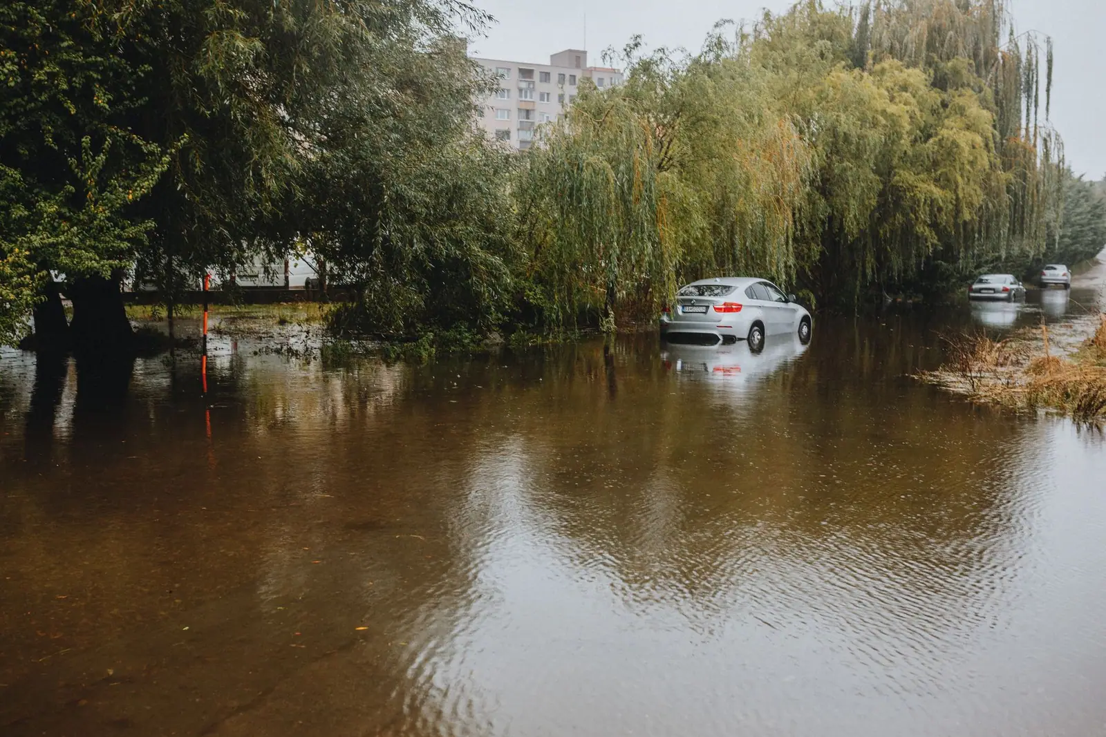 A car standing in flood water on a residential street