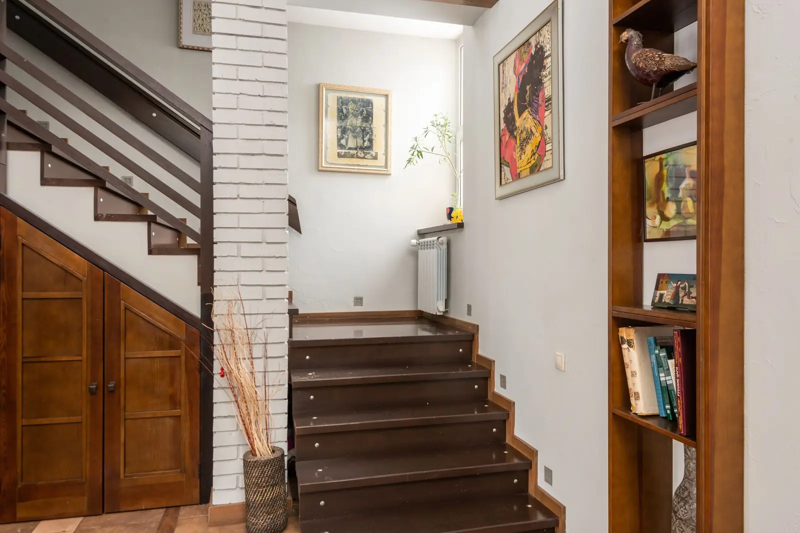 A wooden staircase beside a wall in a house