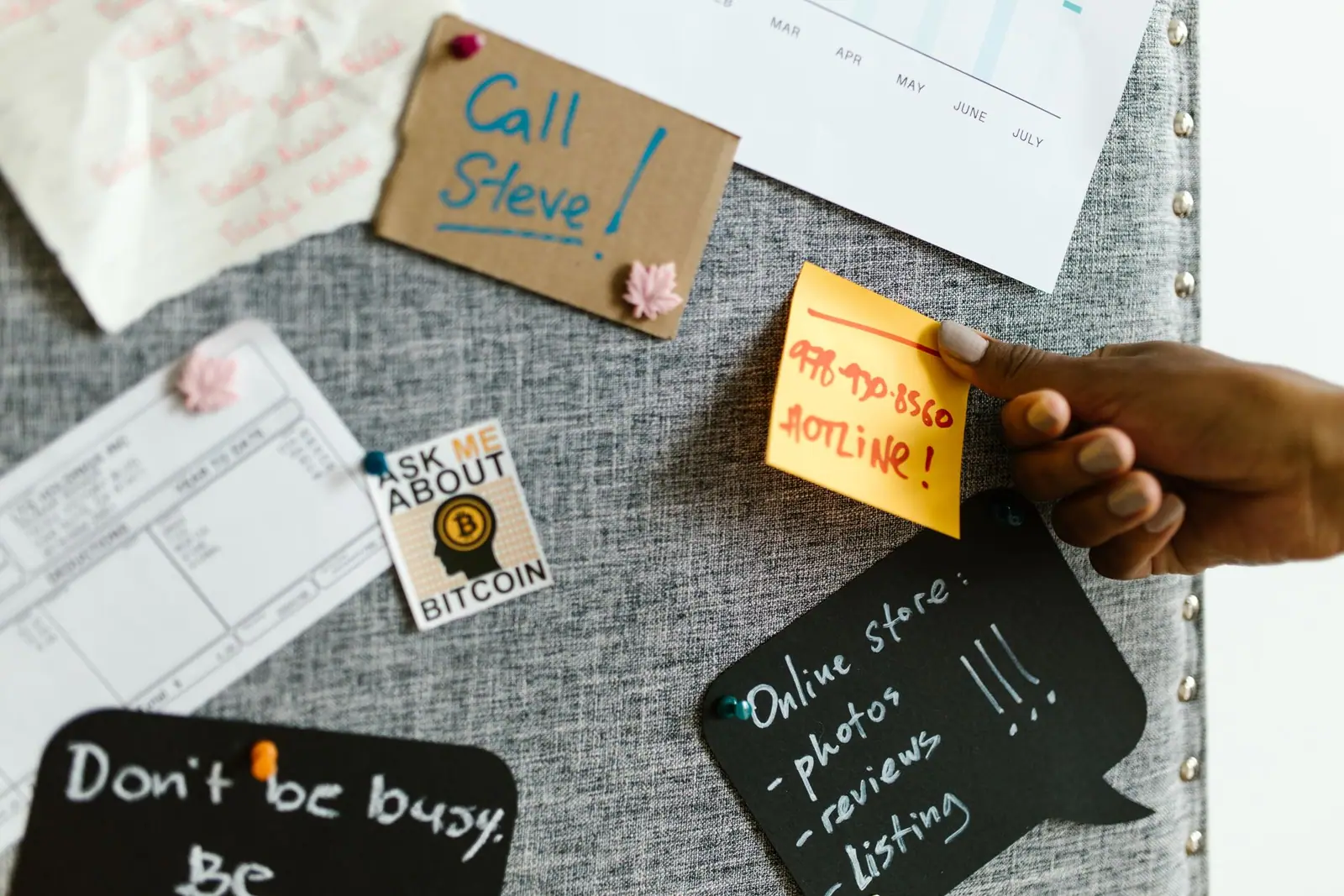 Handwritten notes and cards pinned to a fabric board