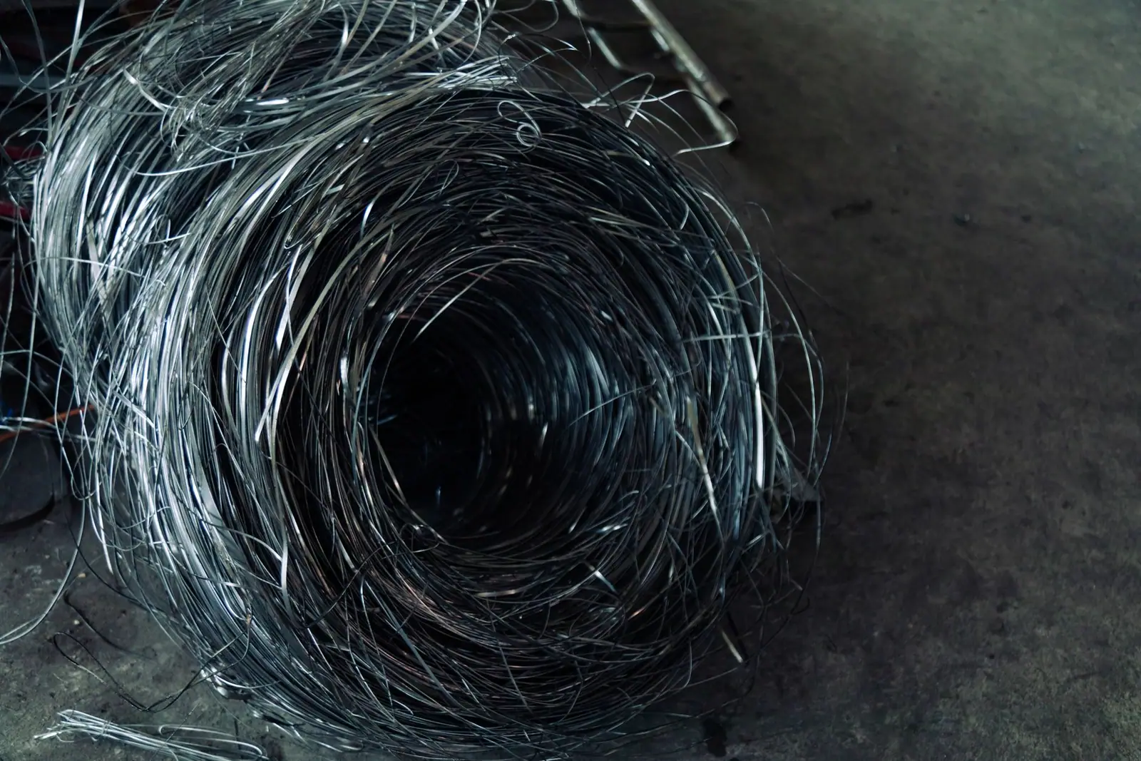 A tangle of wire inside the mouth of a metal pipe
