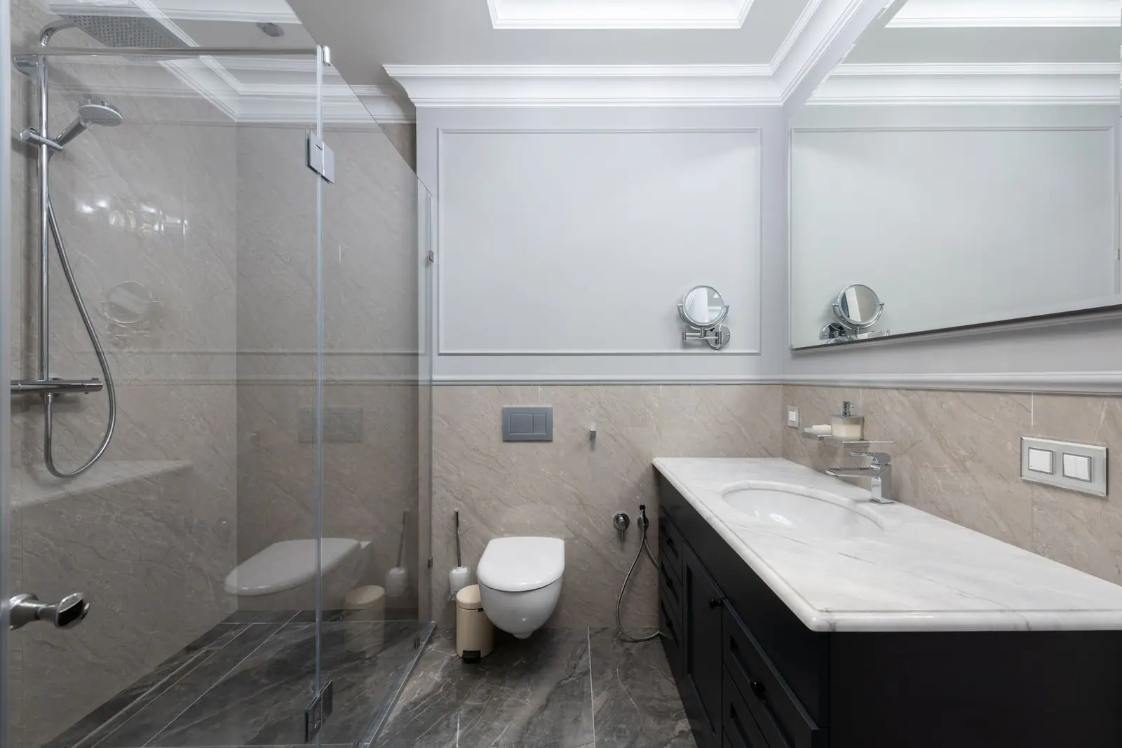 A white toilet beside a bathtub and shower in a bathroom